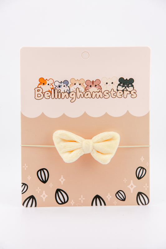 Soft yellow velvet bow accessory for Bellinghamsters plush on a backing card